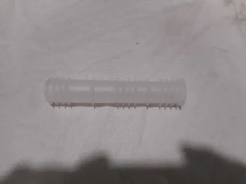 Transparente Hülse von Remeha mit gerillter Oberfläche, auf einer hellen Unterlage positioniert.